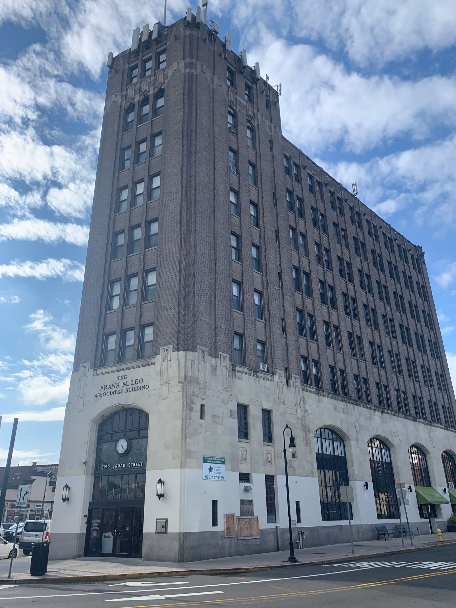 Tall brick building with a stone base on a city street