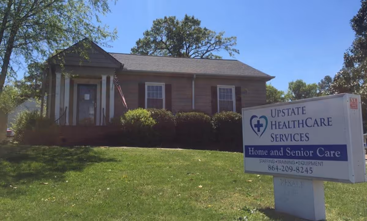 Small single-story building with a sign reading Upstate Healthcare Services on a grassy lawn.