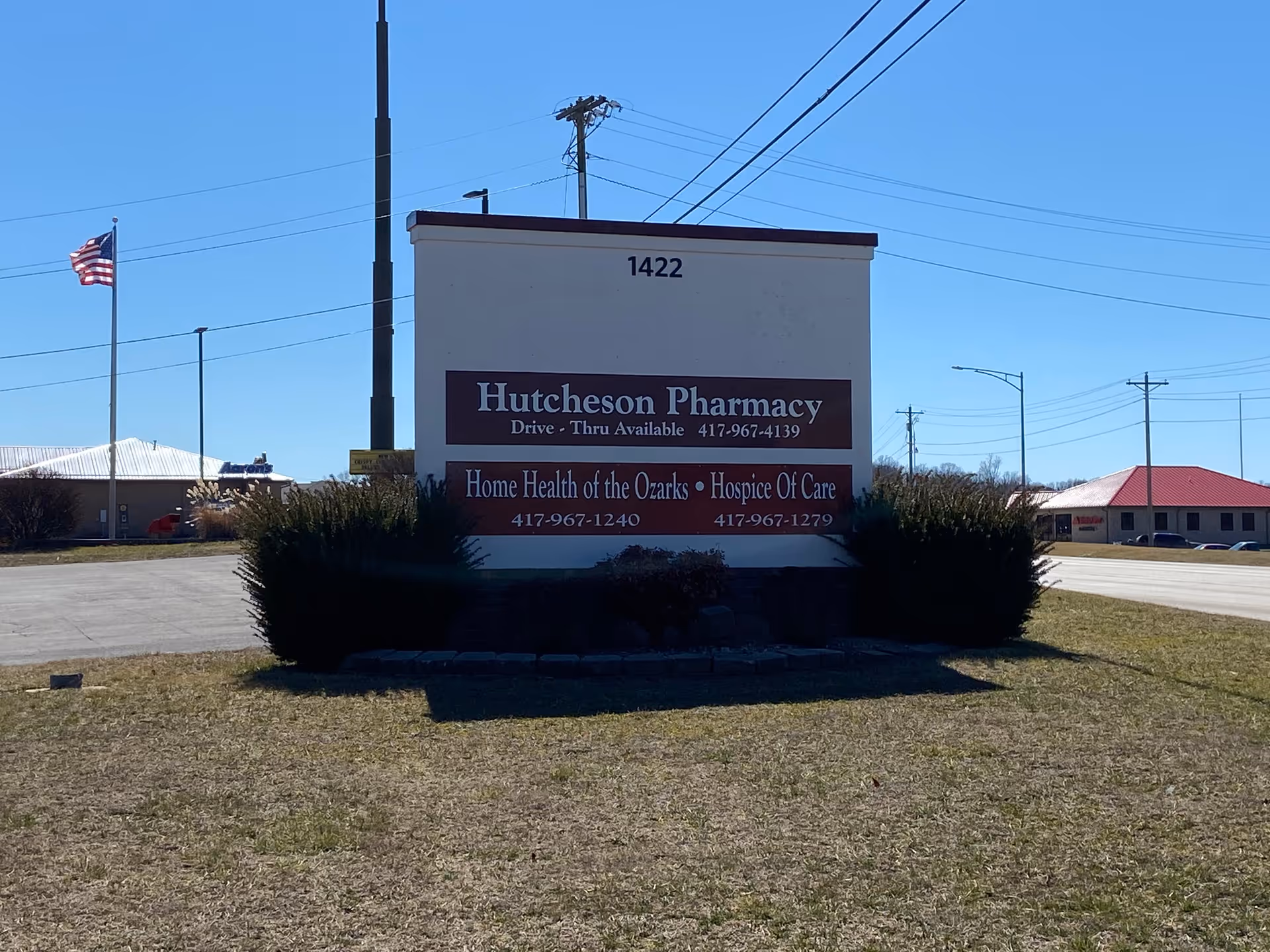 A large sign advertising Hutcheson Pharmacy and Hospice Of Care sits in a parking lot.
