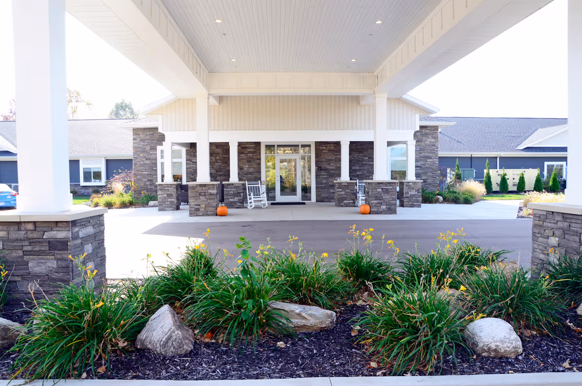 Exterior entrance of Laurel Oaks of South Haven with stone pillars and landscaped foreground.