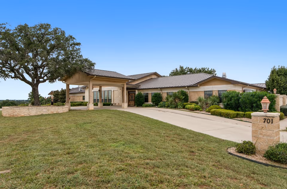 Exterior view of Arbor House Llano with a driveway, lawn, and entrance.