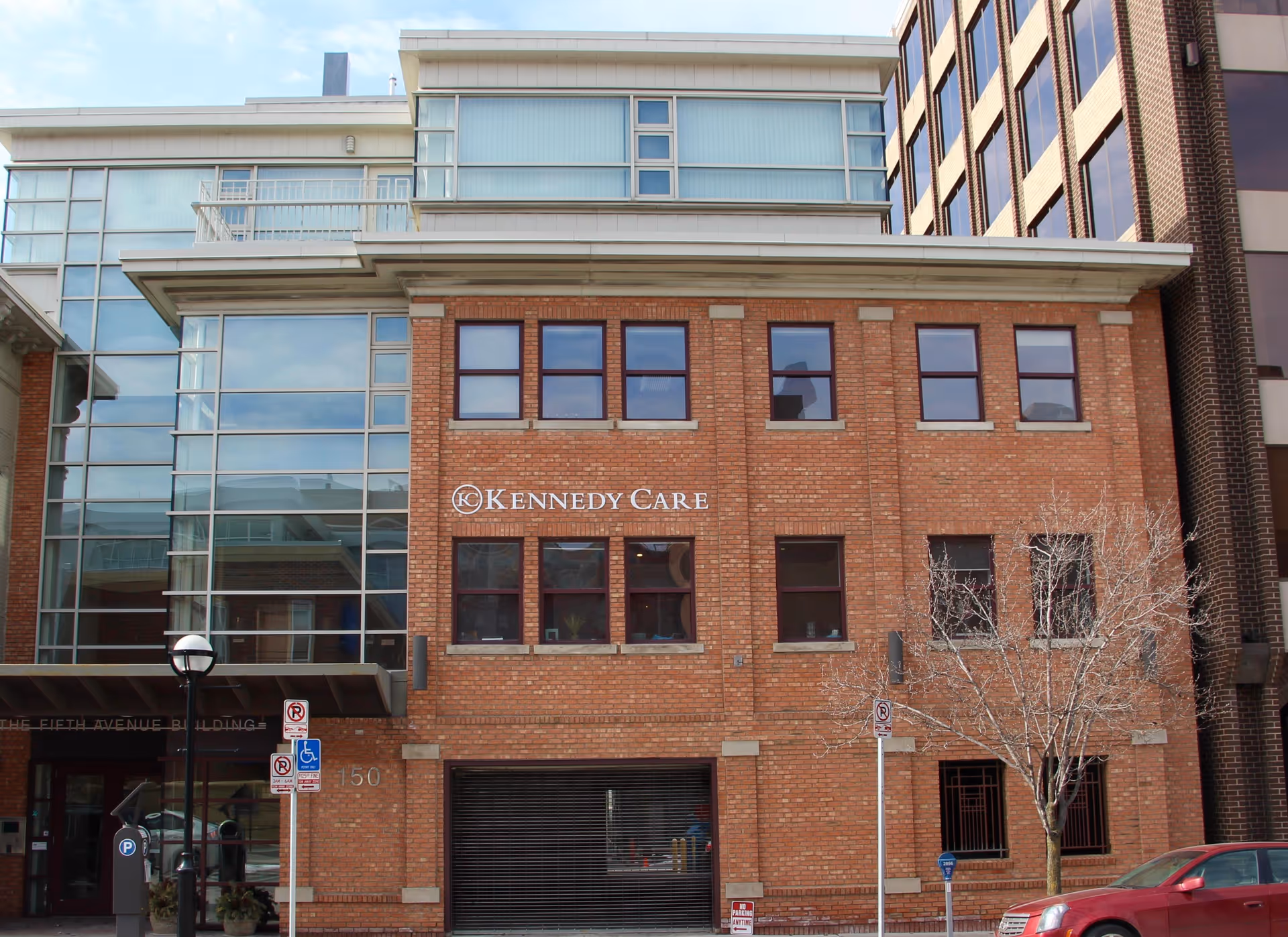 Brick Kennedy Care building facade with glass entrance and windows.