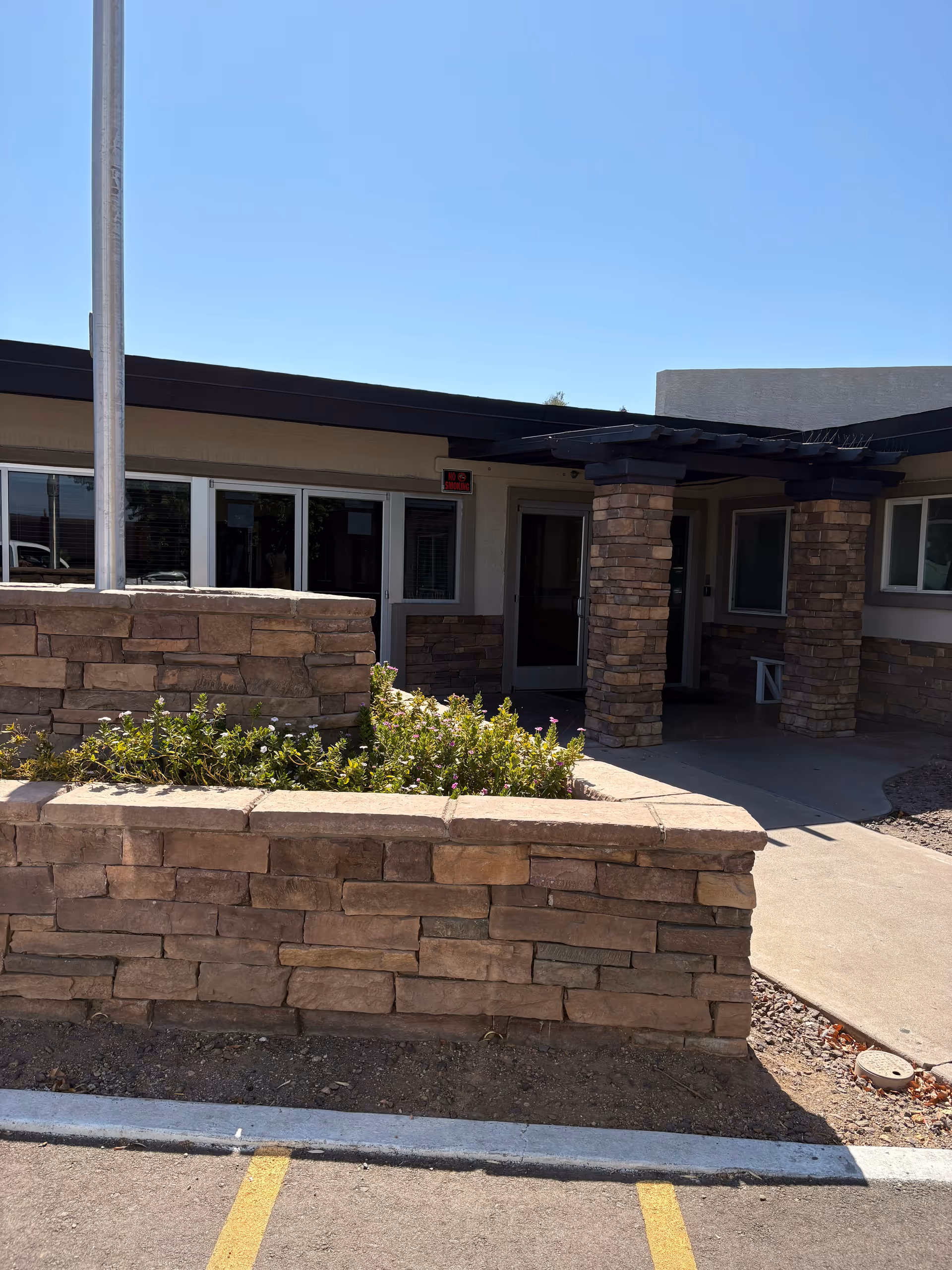 Exterior view of Desert Terrace Healthcare Center entrance with stone pillars and landscaping