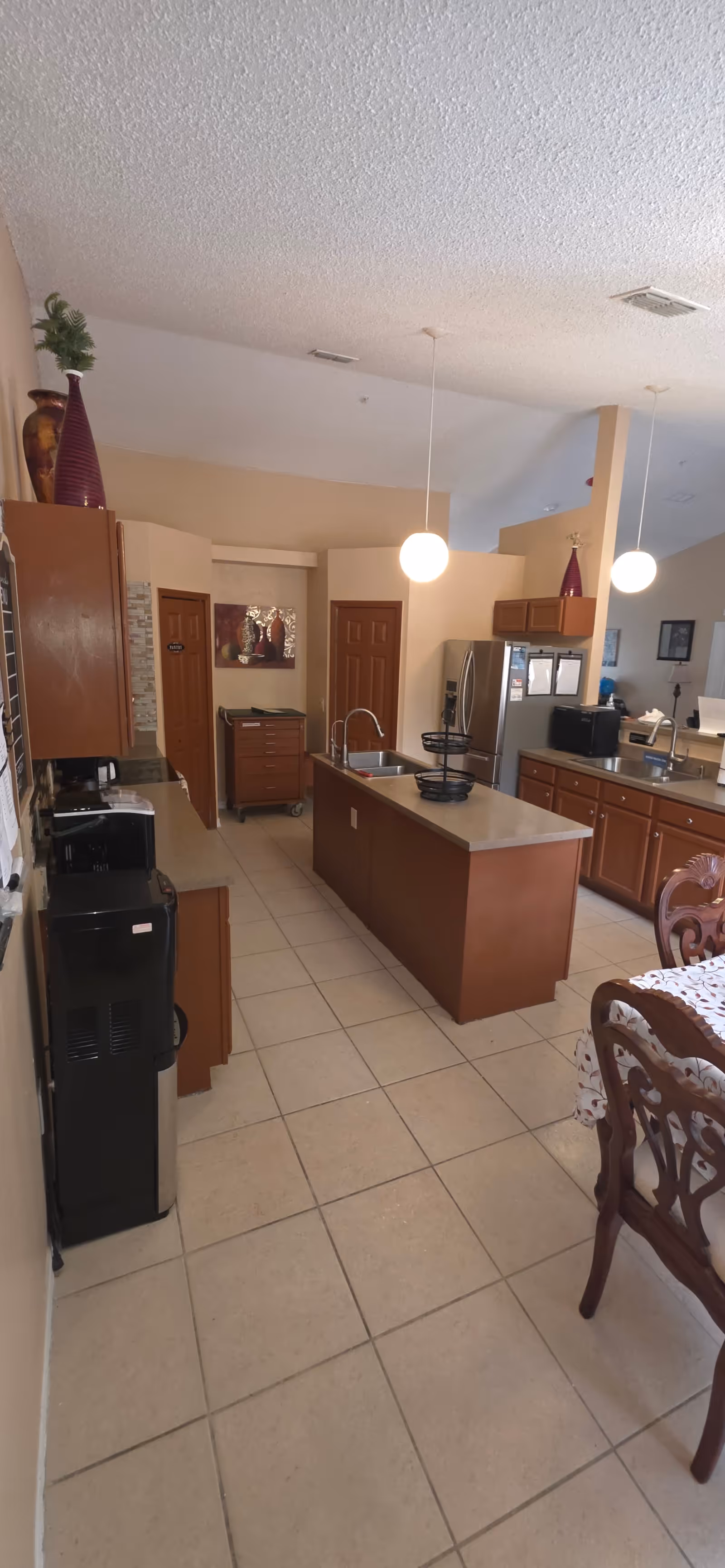 Residential kitchen in a senior living home with a central island and dining table.
