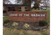 Brick sign reading Lodge of the Wabash sits before a small brick building.