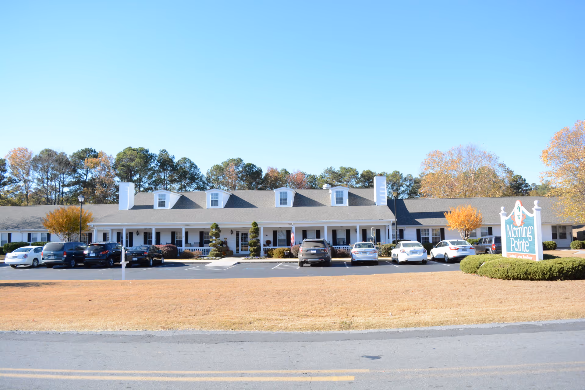 Front view of Morning Pointe of Calhoun with parked cars and a sign.
