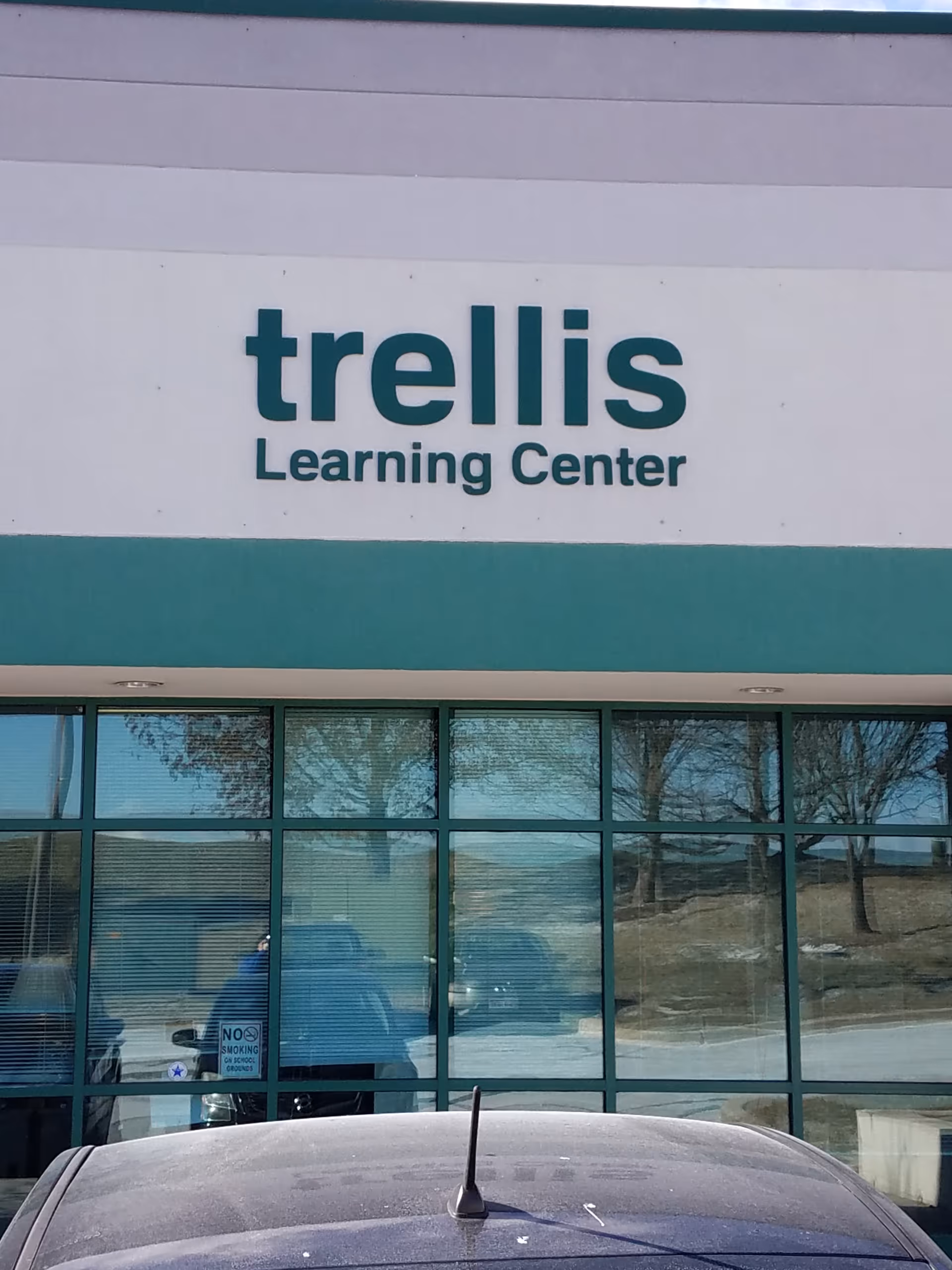 Facade of a Trellis Learning Center with large windows and a parked car.