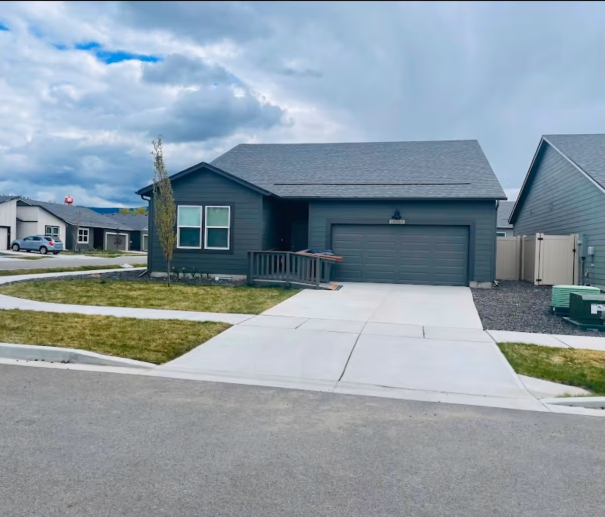 Front exterior view of a gray single-story home with a two-car garage.