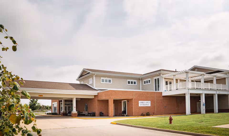 Exterior view of Sunrise Manor Nursing Home with brick entrance and covered driveway.