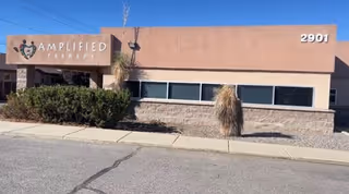 Front view of Amplified Therapy building with signage and desert landscaping.