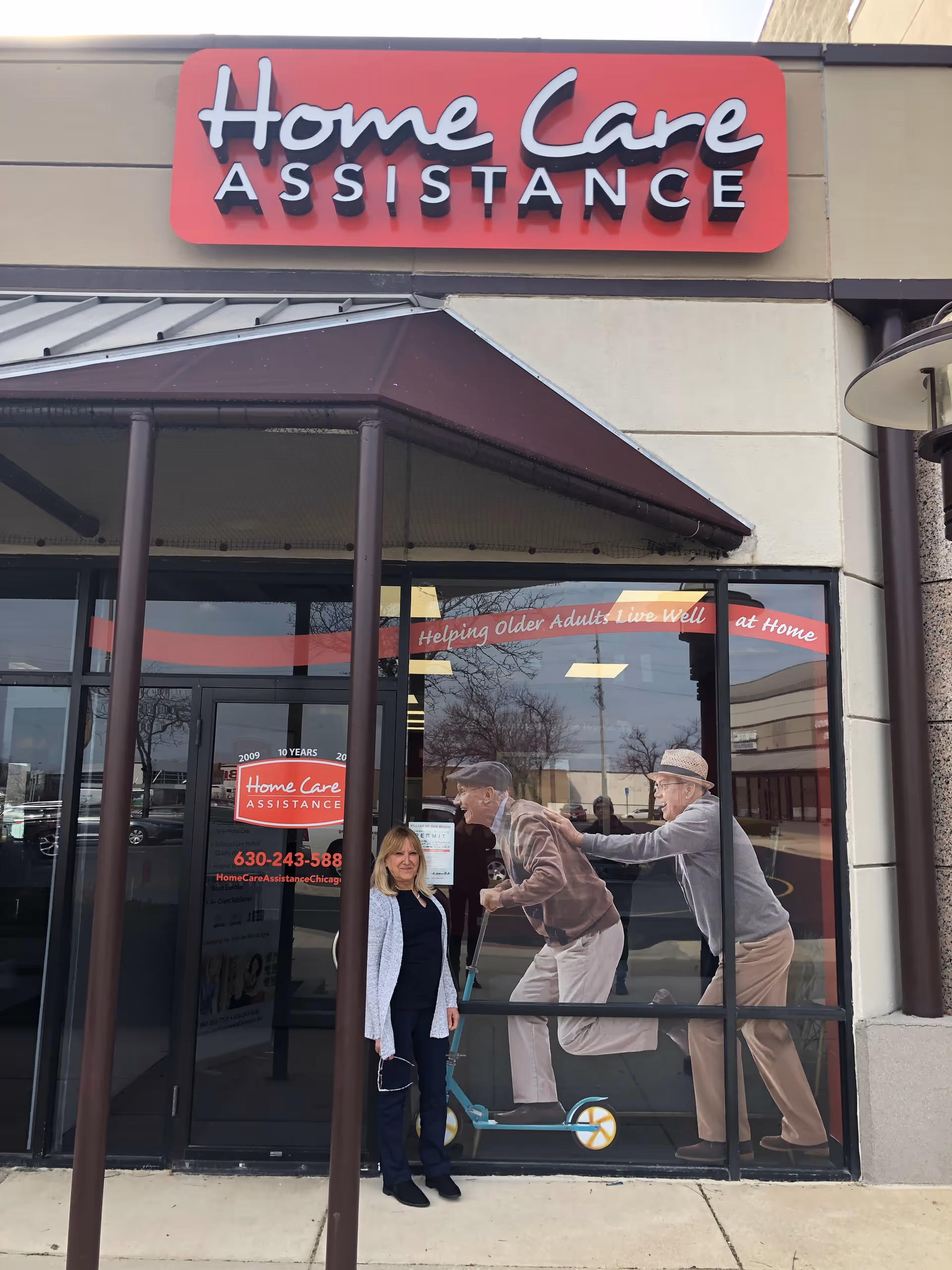 Storefront of Home Care Assistance with two people outside near glass doors