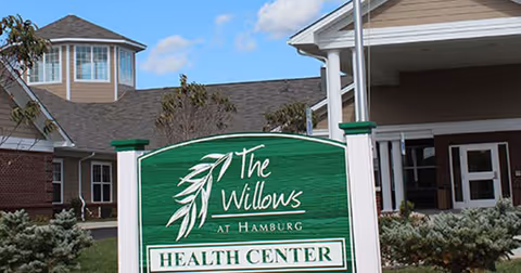 Exterior view of The Willows at Hamburg Health Center with a green sign in foreground.