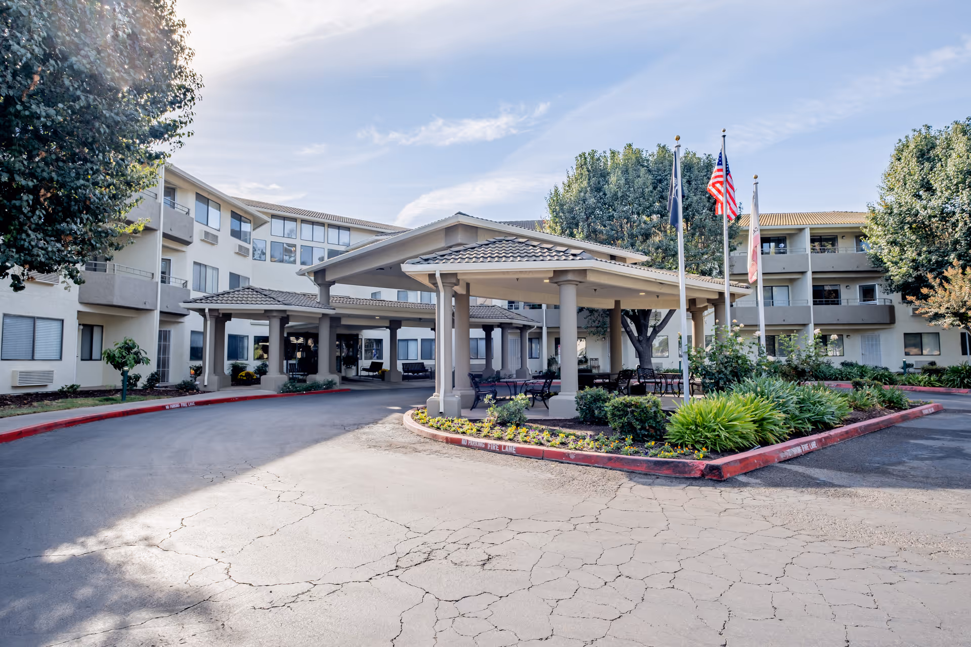 Exterior view of Truewood by Merrill Modesto, showing entrance canopies, drive, and landscaping.