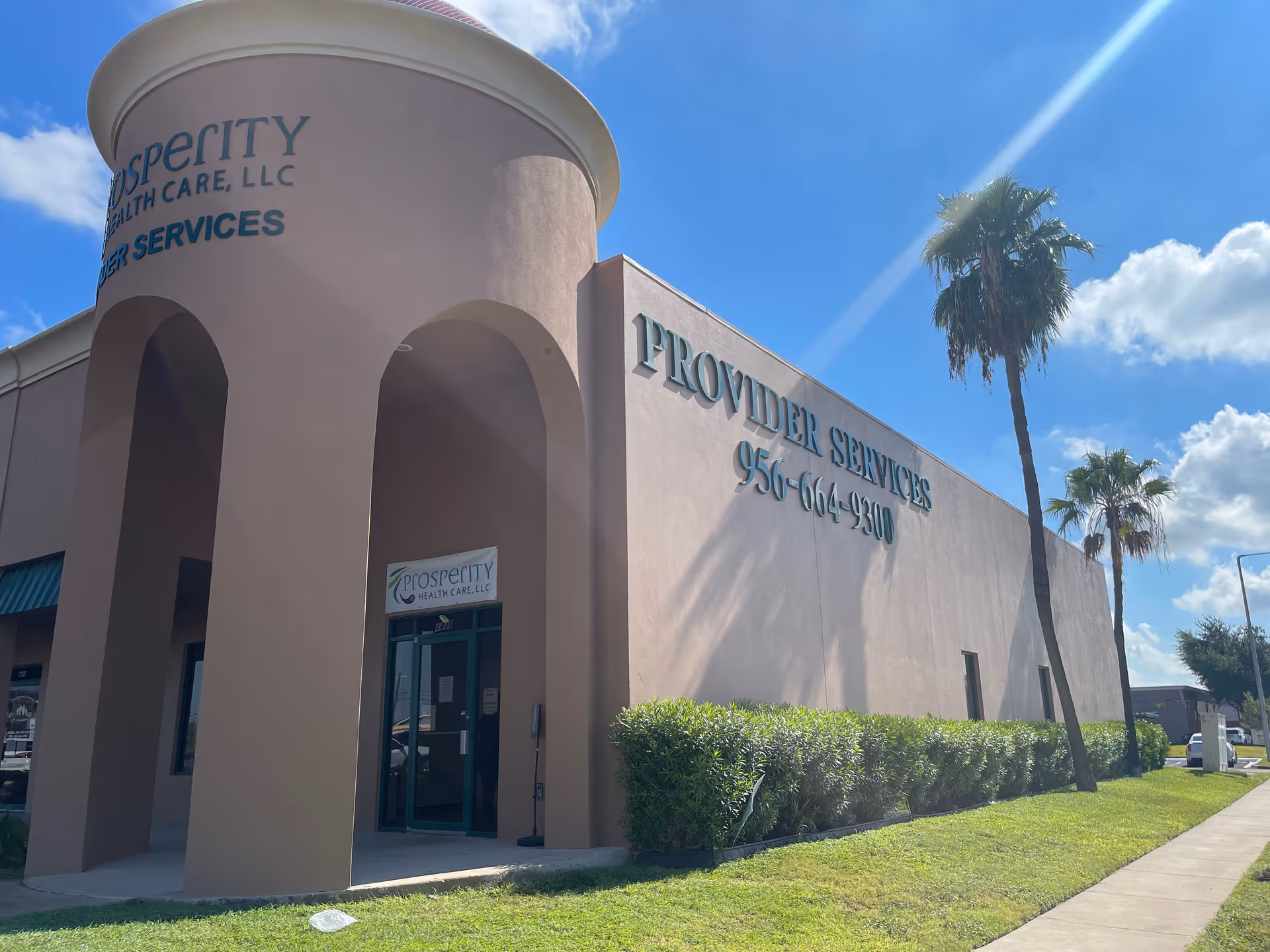Exterior view of Prosperity Health Care LLC building with palm trees and blue sky.