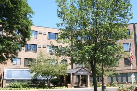 Exterior view of Wellhaven Senior Living building with entrance canopy and trees.
