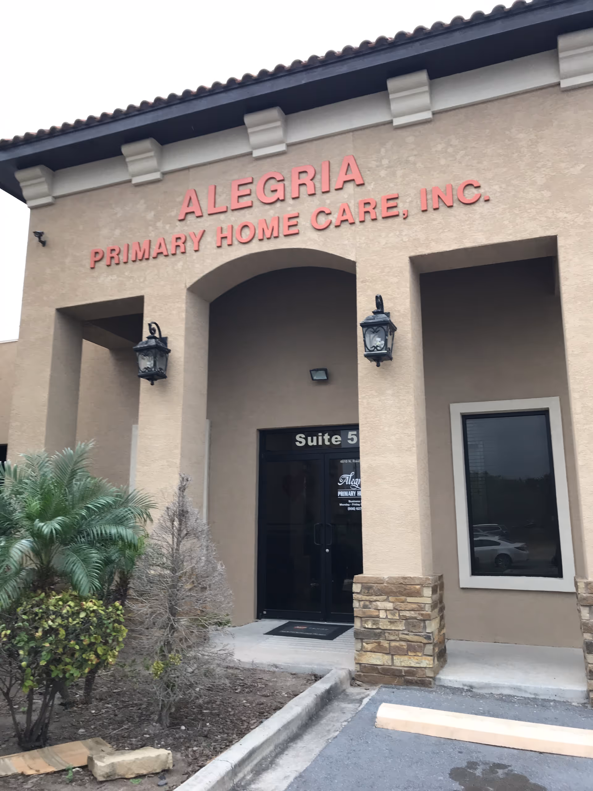 Front entrance of Alegria Primary Home Care, Inc., beige exterior with lantern lighting.