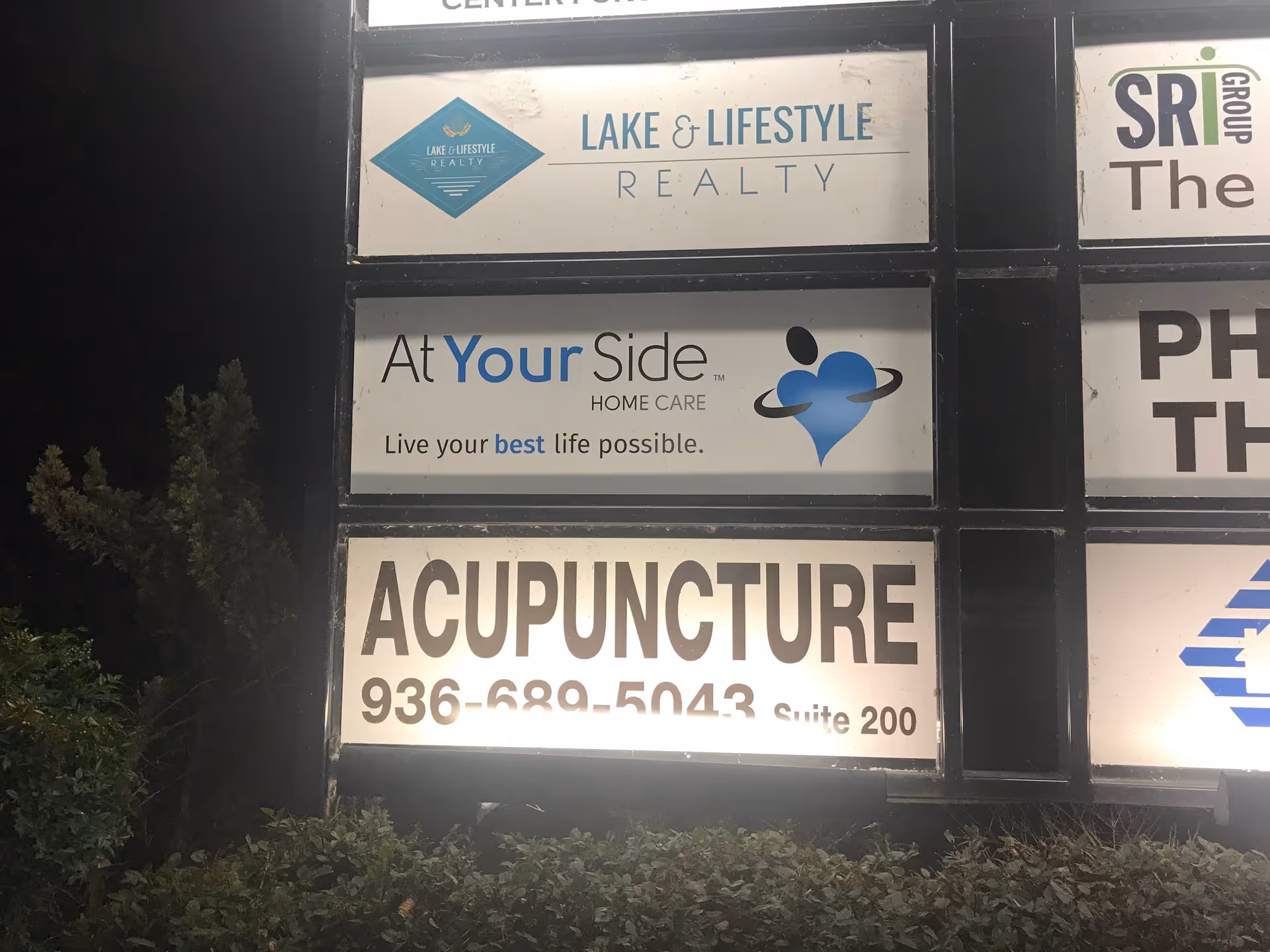 Exterior signboard featuring At Your Side Home Care Montgomery TX, with other business signs.
