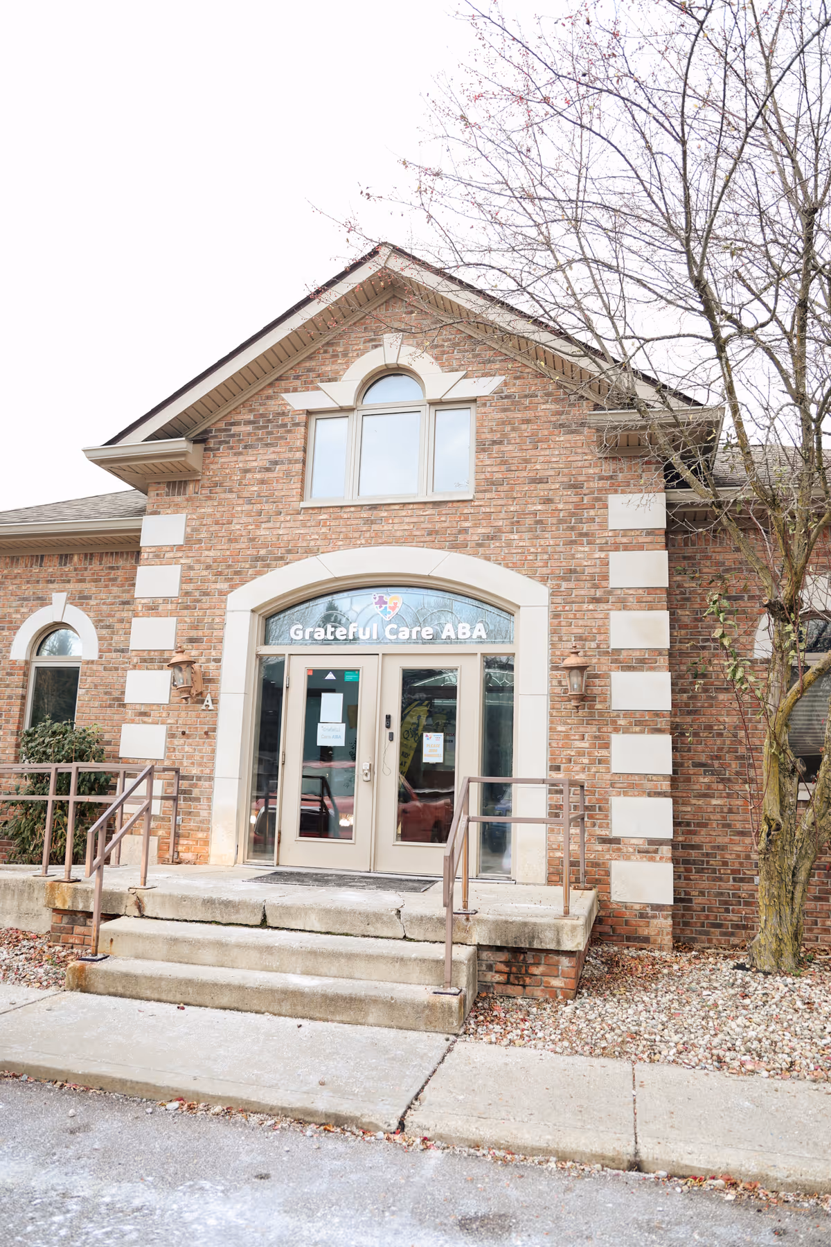 Brick facility entrance with arched doorway and Grateful Care ABA sign