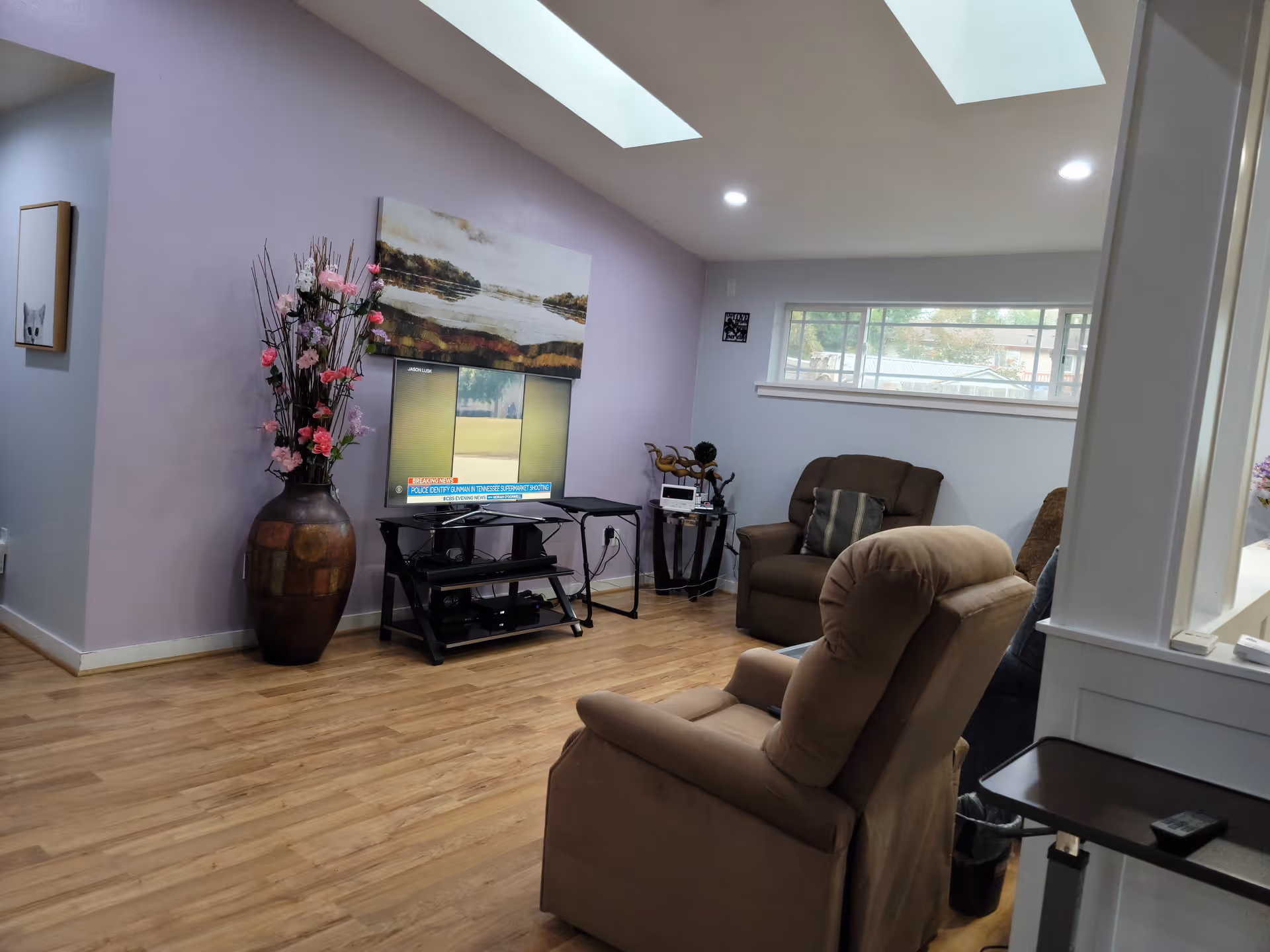 An inviting living room with recliners, a TV, and lavender walls.