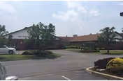 Exterior view of Mid-Valley Health Care Center with parking and landscaping in front.