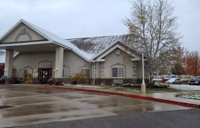 Exterior view of Beehive Homes of Santaquin with entrance and parked cars.