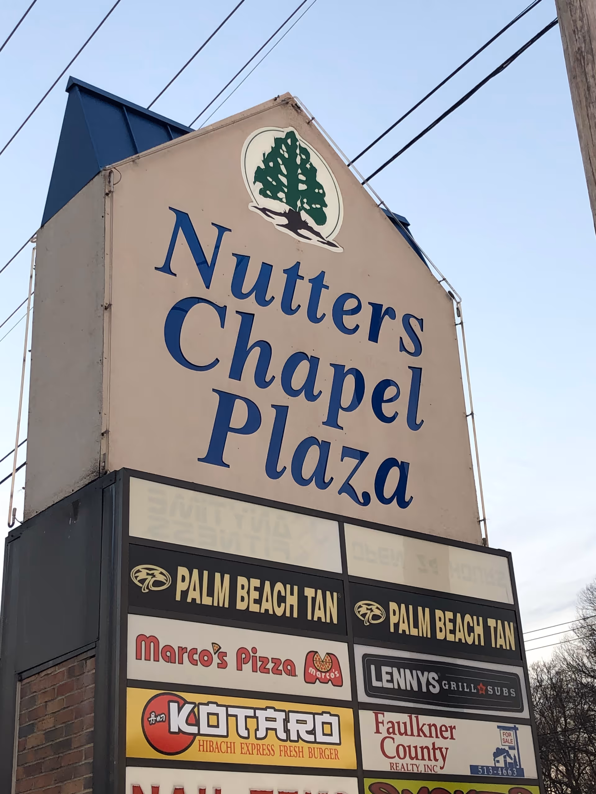 A large sign reads Nutter's Chapel Plaza with shop signs beneath.