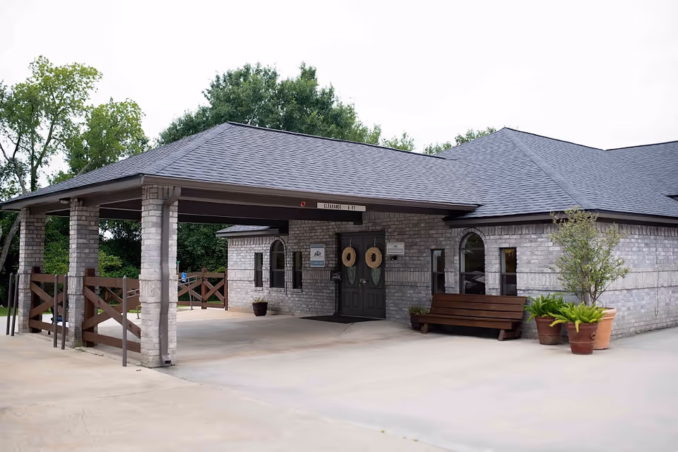 Exterior view of a stone Edgerton Care Center entrance with a covered drop-off area and benches.