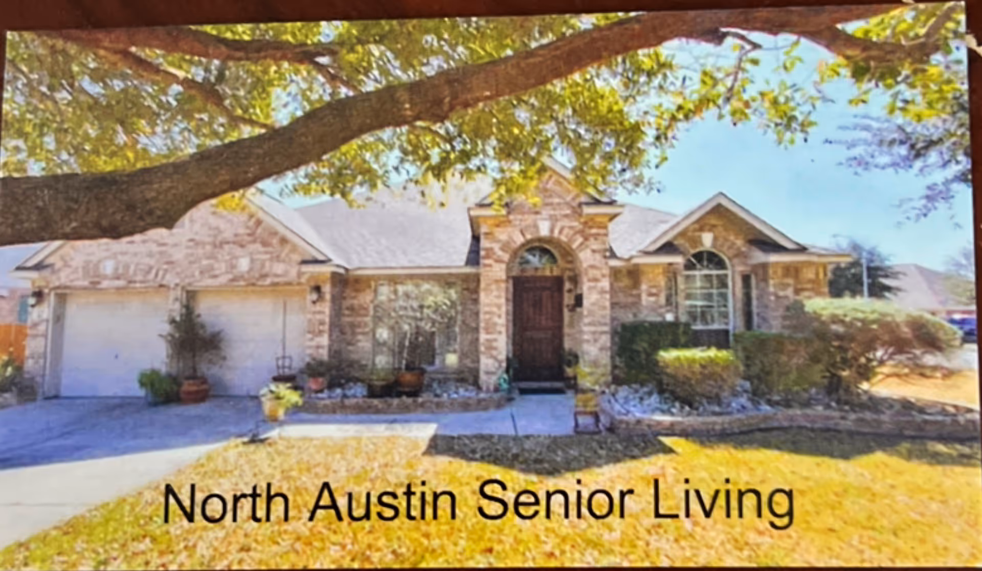 Front exterior of North Austin Senior Living, a single-story brick facility with landscaped entry.