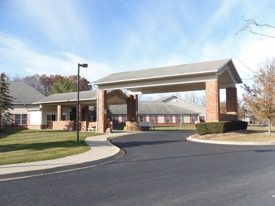 Brick building with a large covered entrance and circular driveway.