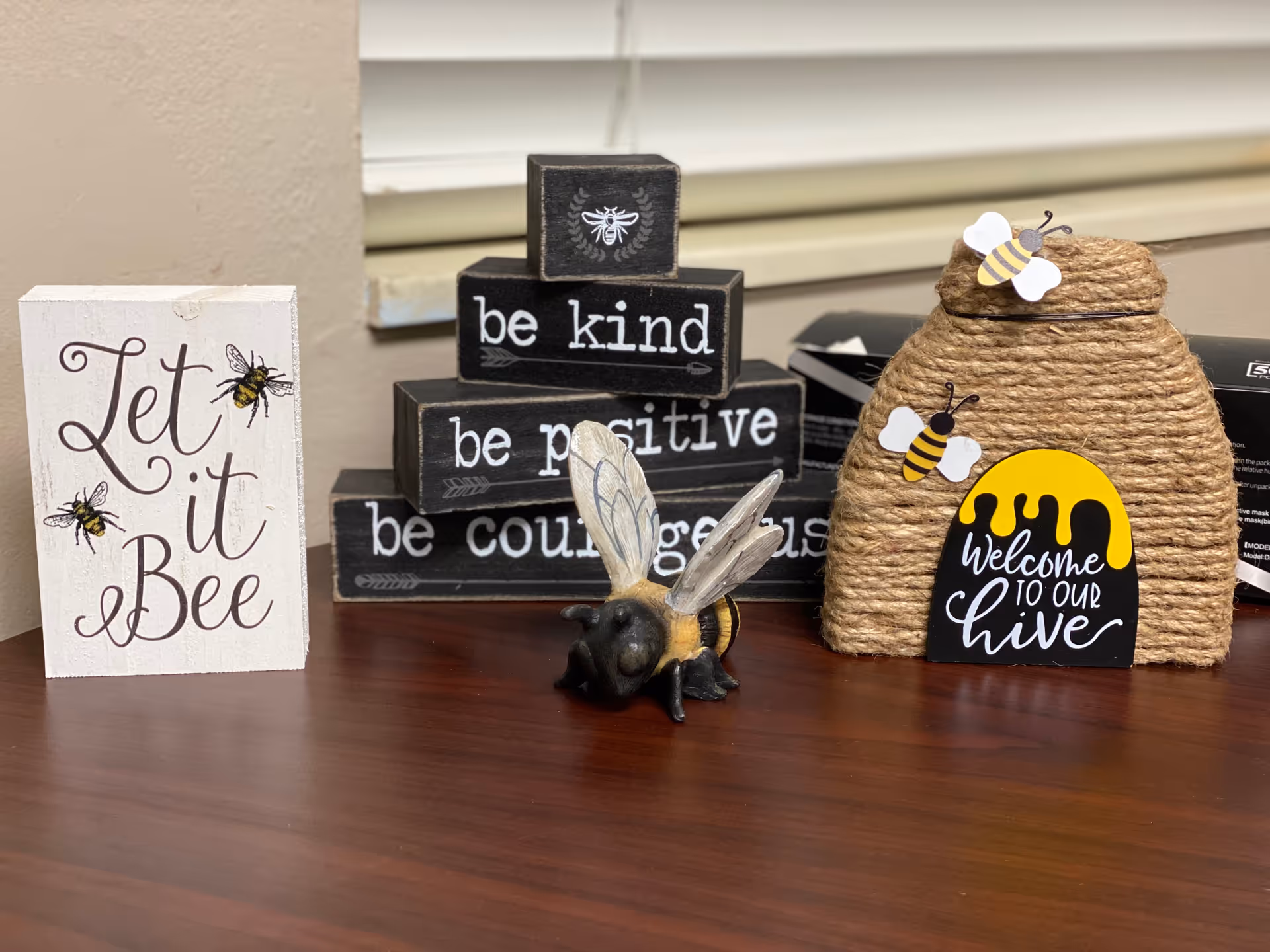 Bee-themed desk decor with signs reading 'Let it Bee', 'be kind', and a honey hive.