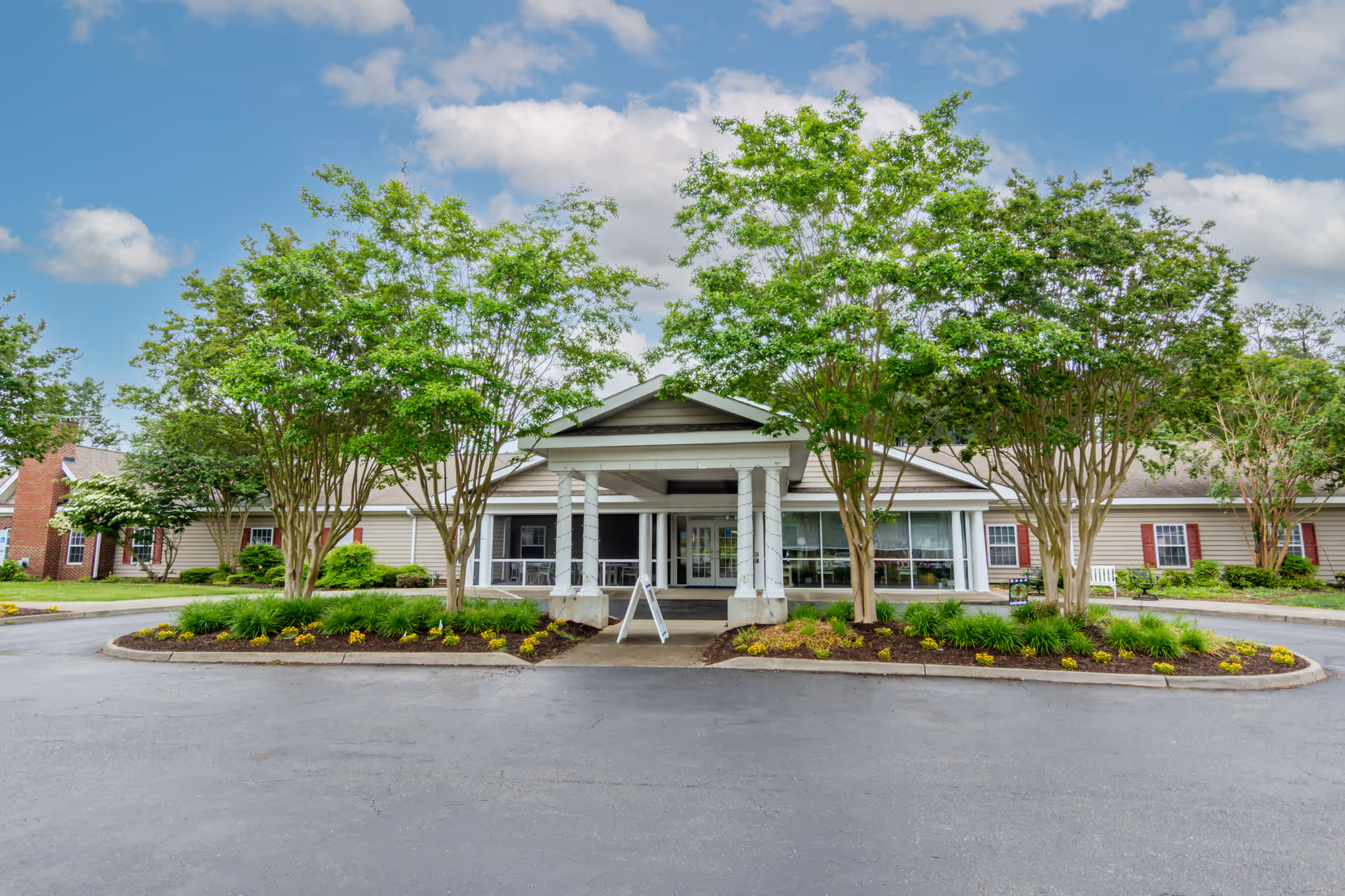 Front view of Commonwealth Senior Living at Kilmarnock with a landscaped entrance and trees.