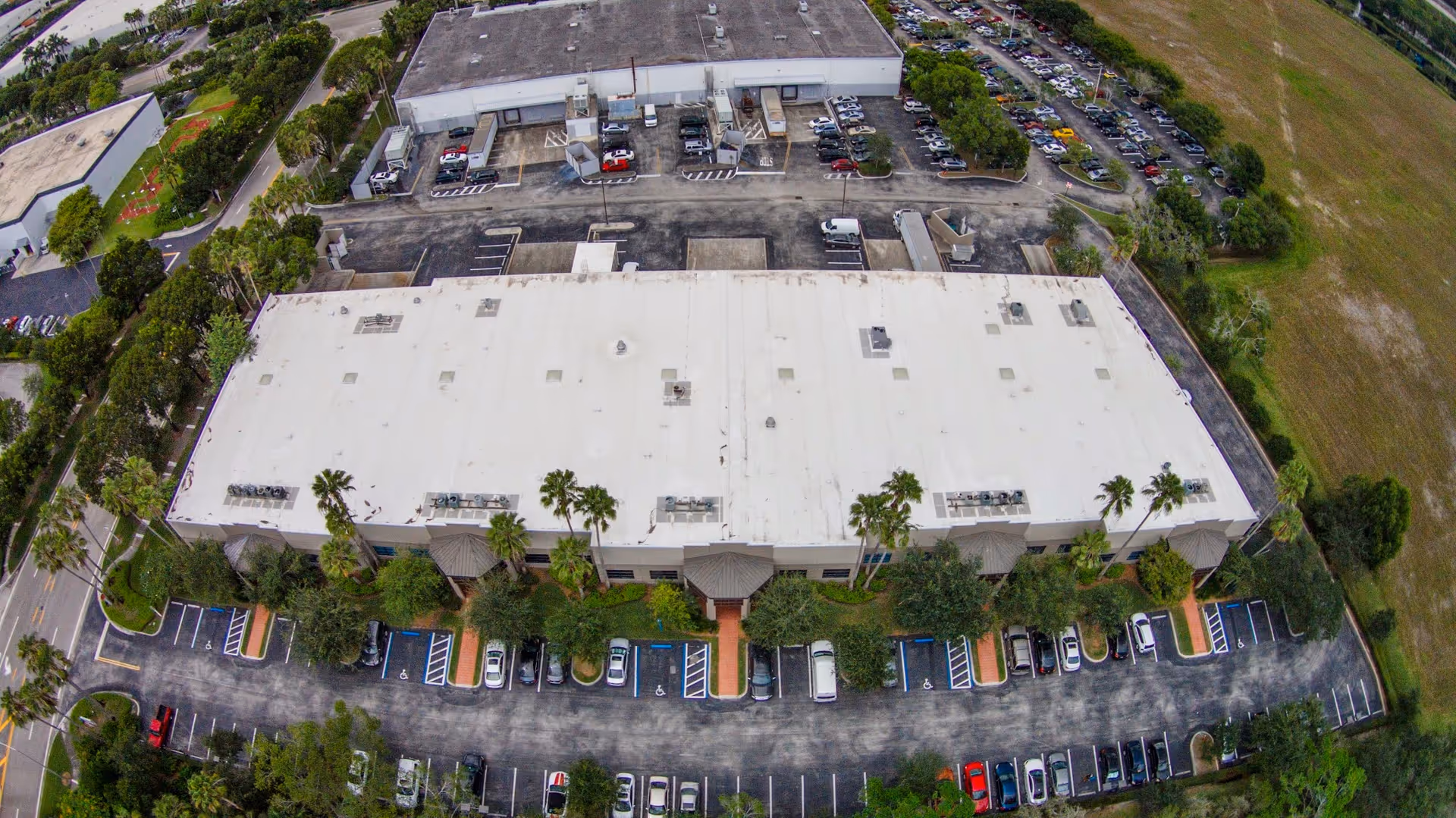 Aerial view of a large rectangular senior living facility with surrounding parking and greenery.