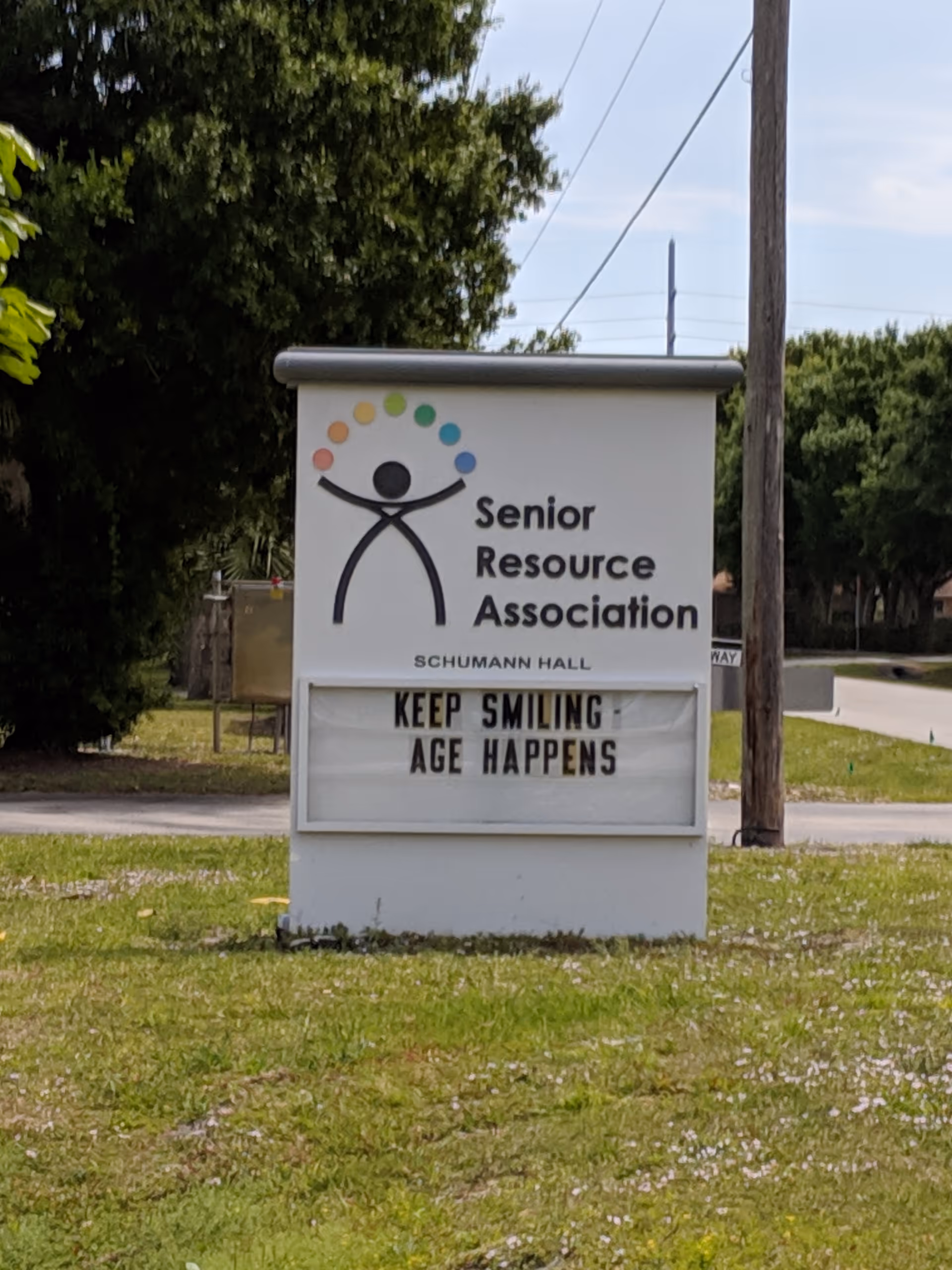 Outdoor sign for Senior Resource Association on a grassy lawn with logo and lettering.