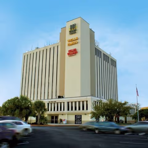 Tall beige, multi-story building with PhilAm Home Care Inc signage on the front.