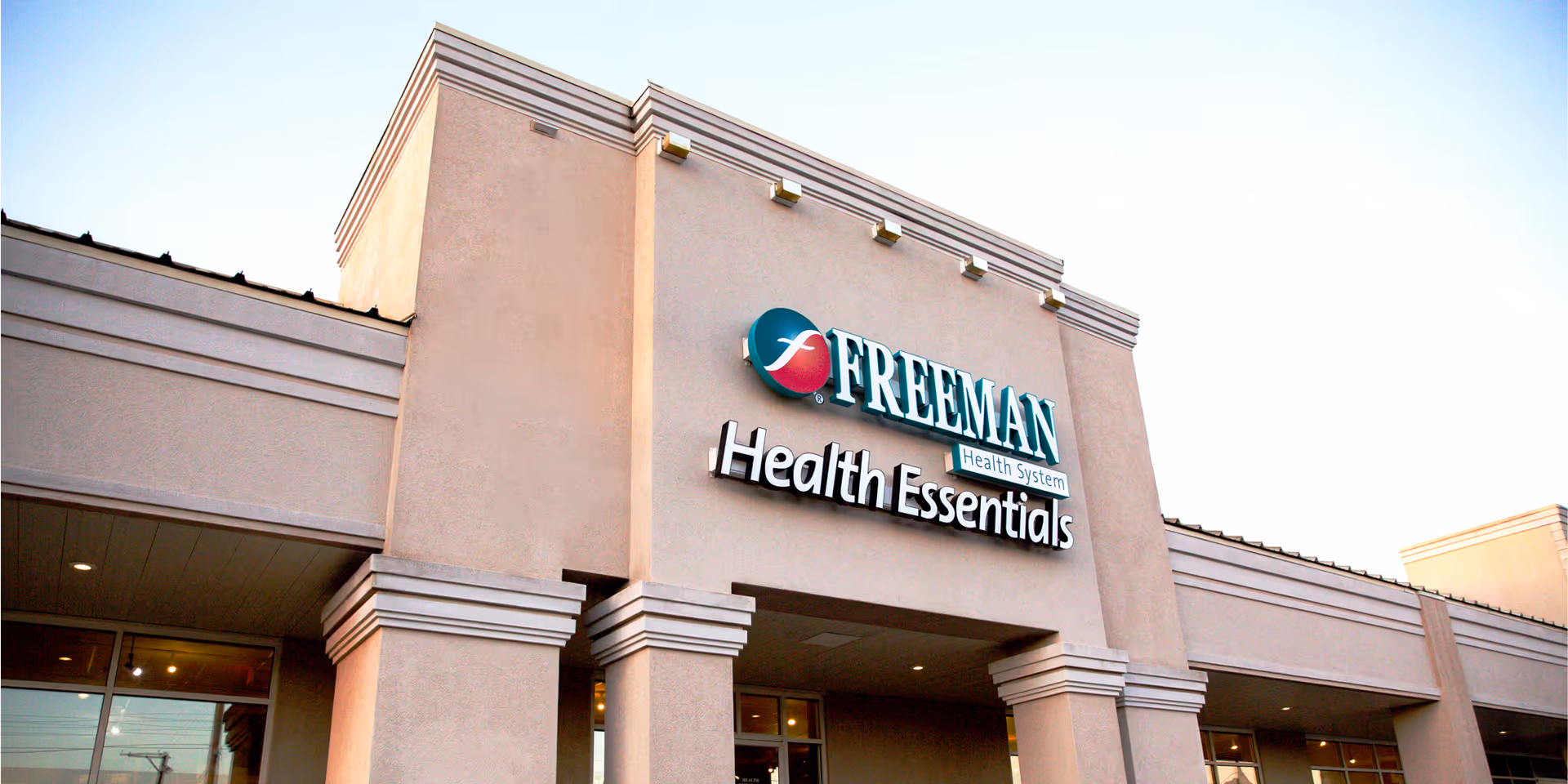 Exterior view of Freeman Health Essentials facility with signage and entrance arches.