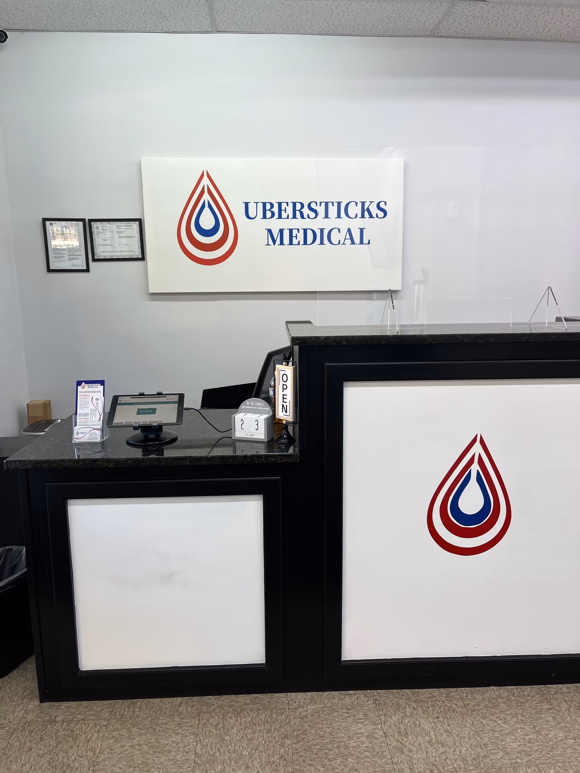 Reception desk with a large UBERSTICKS MEDICAL sign on the wall.