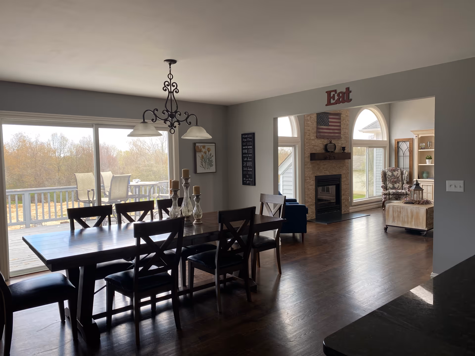 Dining area featuring a long wooden table, chandelier, and sliding glass doors to the deck.
