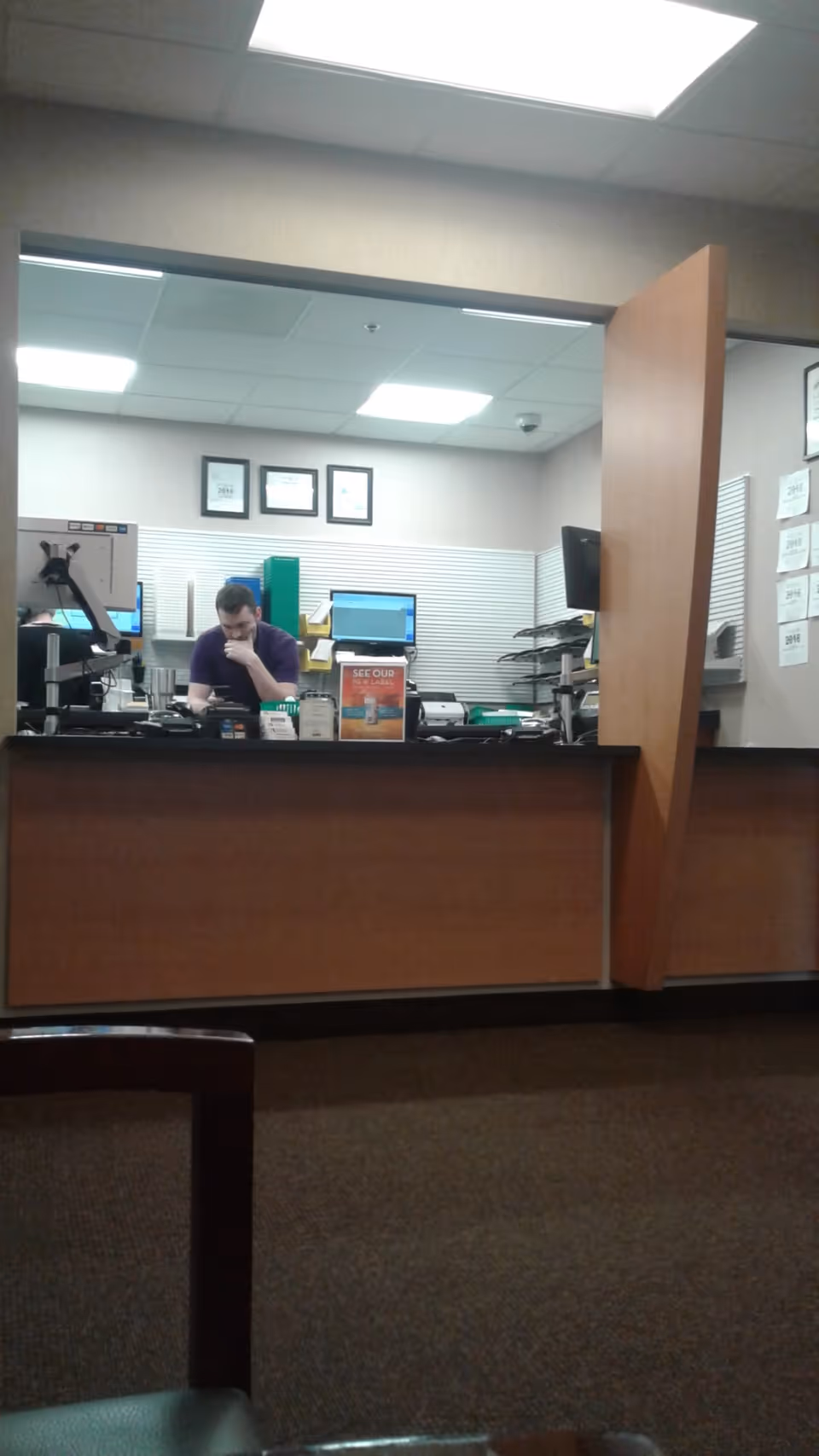 A front desk area inside a facility with a staff member at the counter.