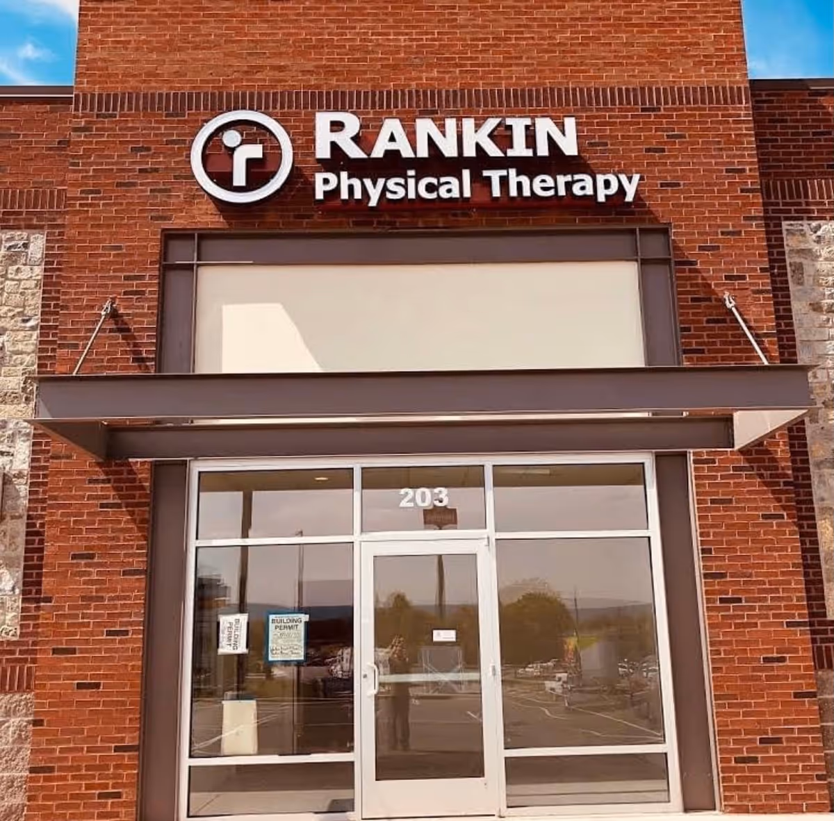 Brick building exterior with Rankin Physical Therapy sign above glass entrance doors.