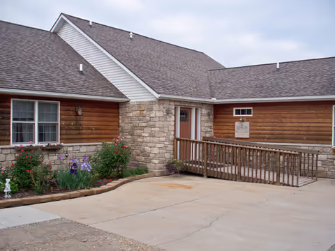 Exterior view of Honey Creek Cottage facility with stone entryway and ramped porch.