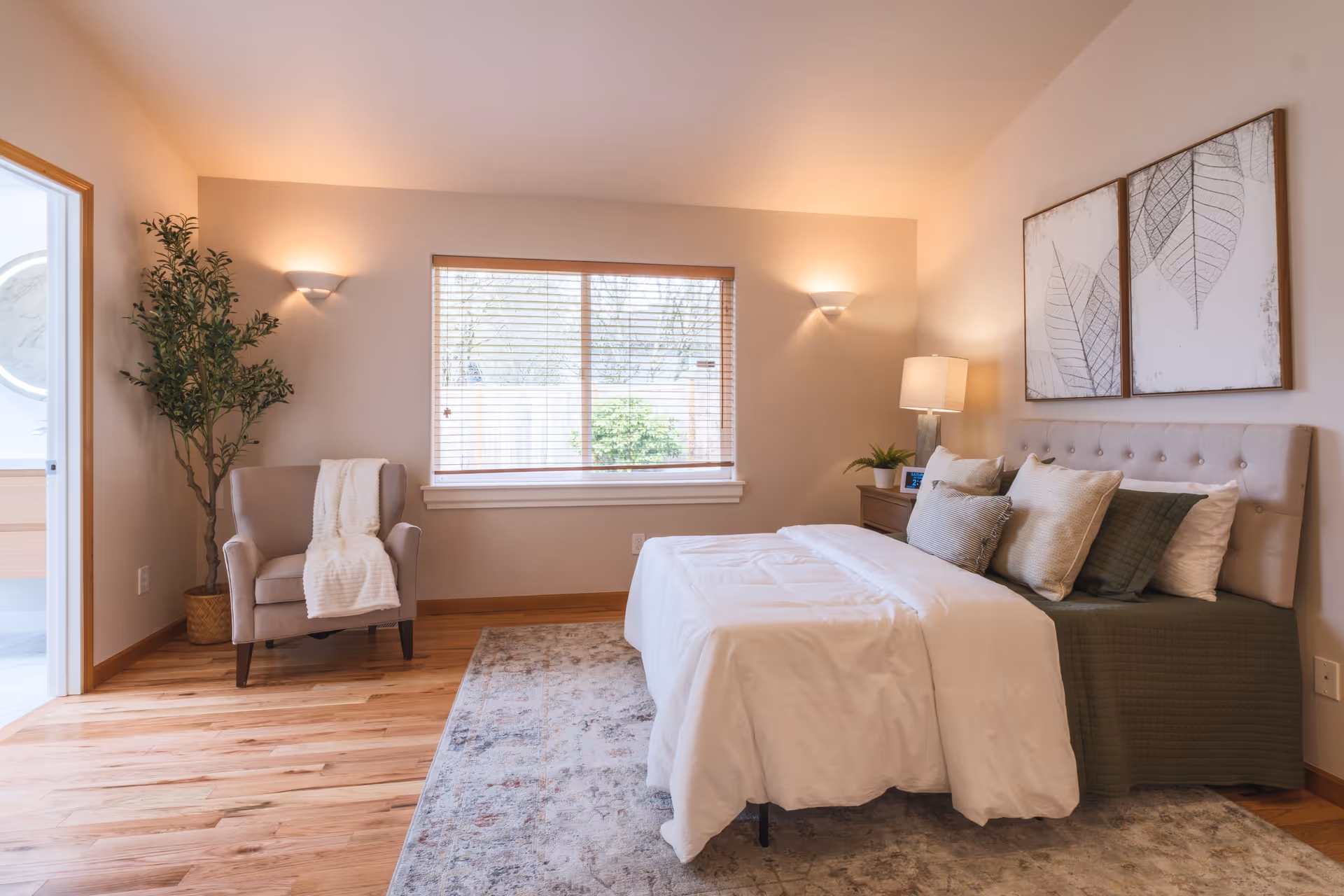 Bright, cozy bedroom with a bed, armchair, plants, window, and soft ambient lighting.