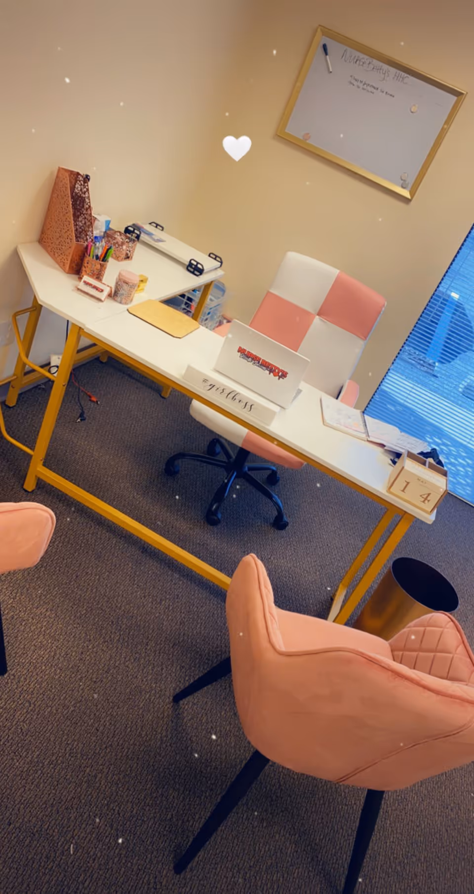 A neat office desk with pink chairs in a senior care facility reception area.