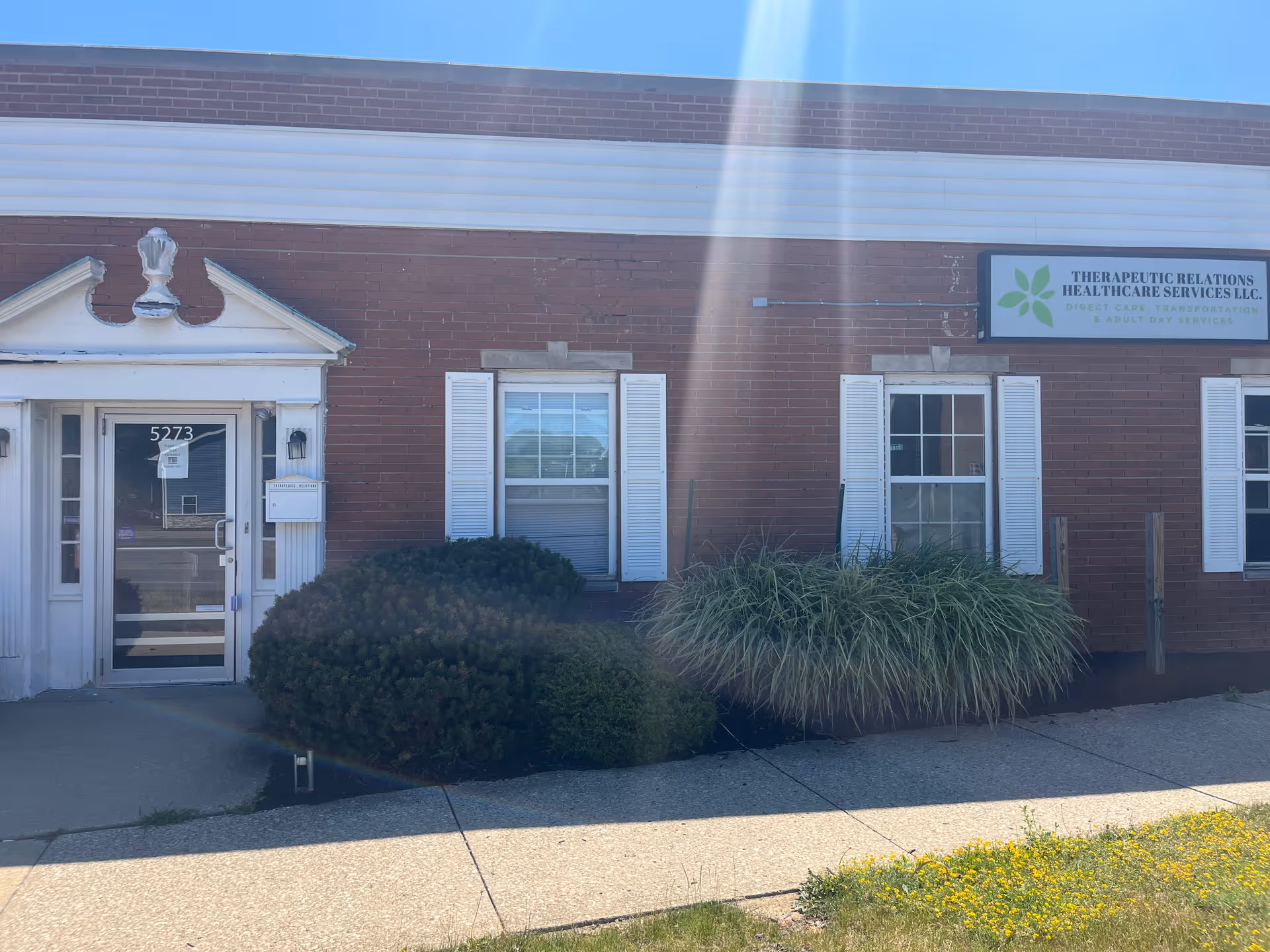 Brick building exterior with entrance, sign for Therapeutic Relations Healthcare Services LLC, and landscaping.