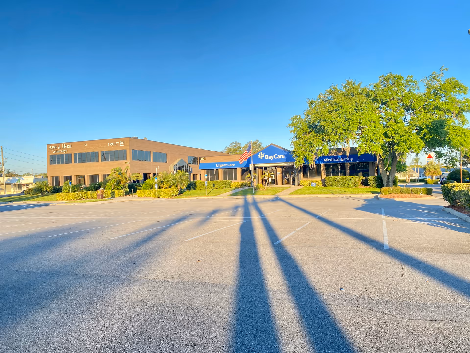 Exterior view of a strip plaza with medical clinics and a parking lot.