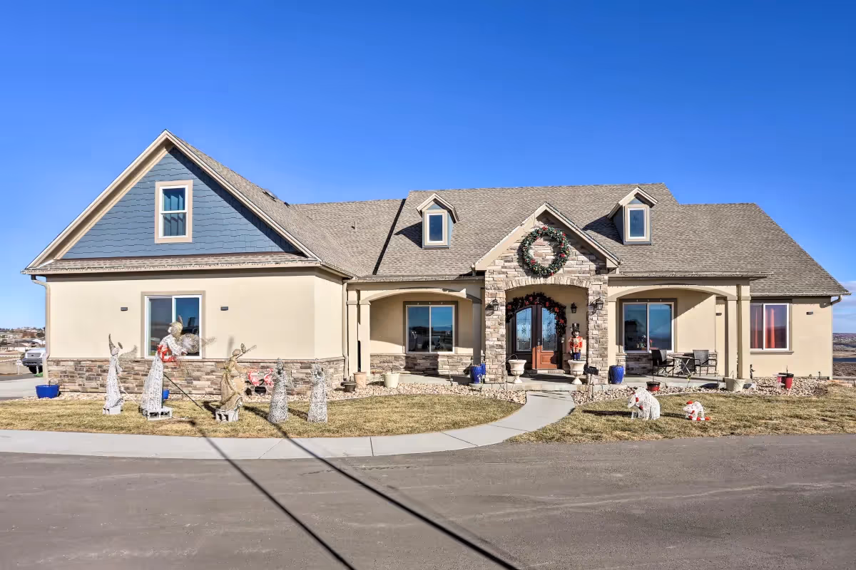 Front exterior of a memory care facility with wreaths and lawn decor.