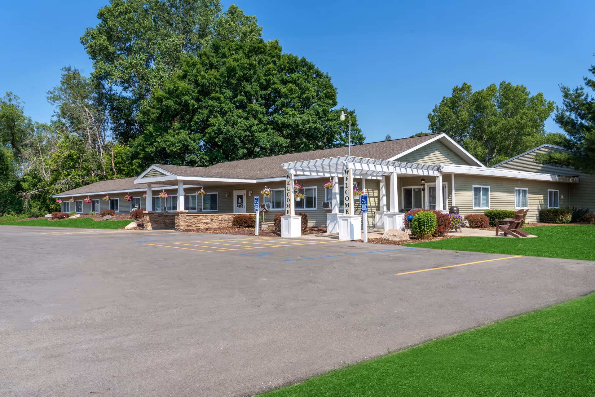 Exterior view of Americana Seniors facility: single-story building with covered entrance and manicured lawn.