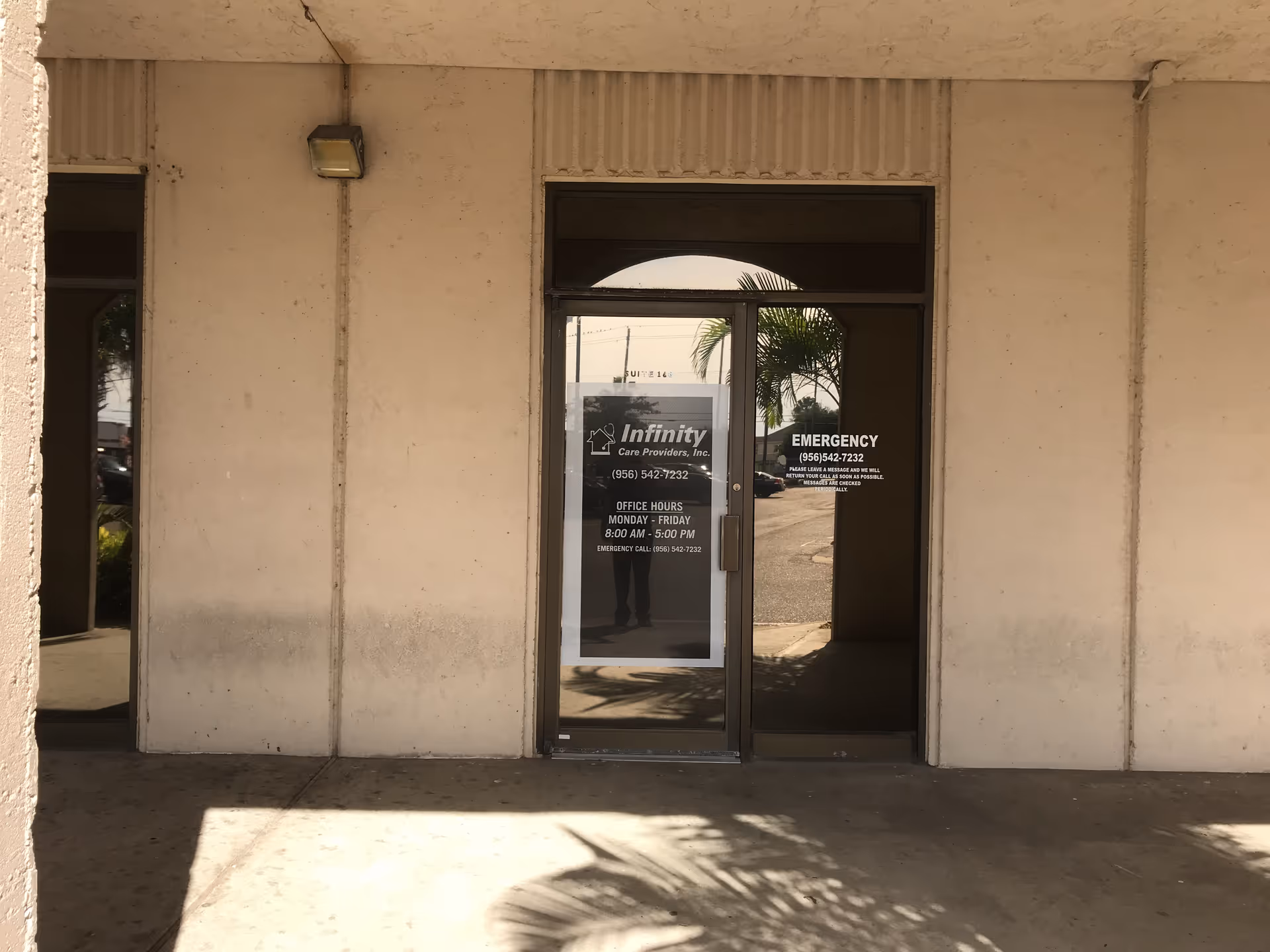 Front entrance of Infinity Care Providers building with glass door and signage.