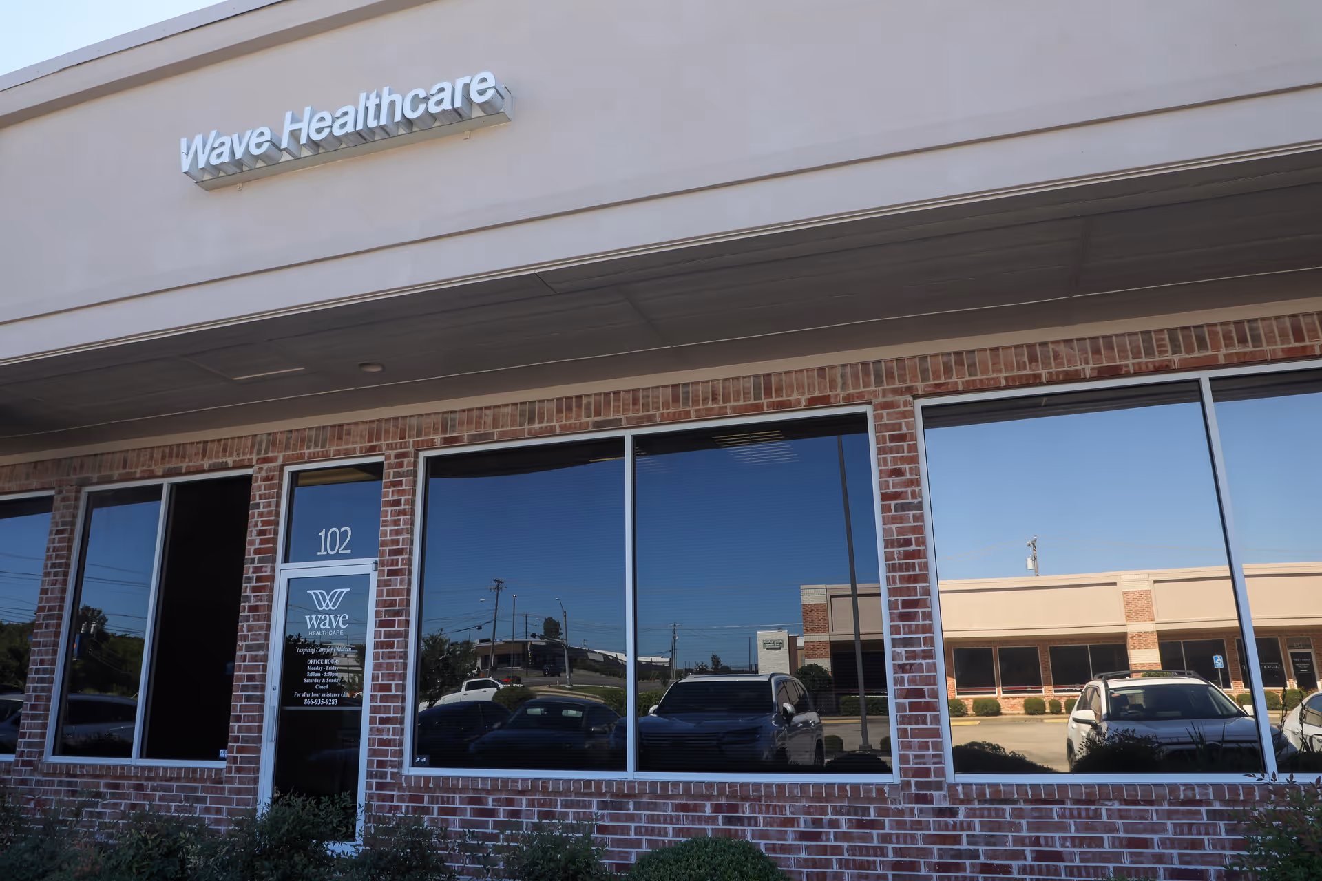 Front exterior of Wave Healthcare building with brick facade and large windows.