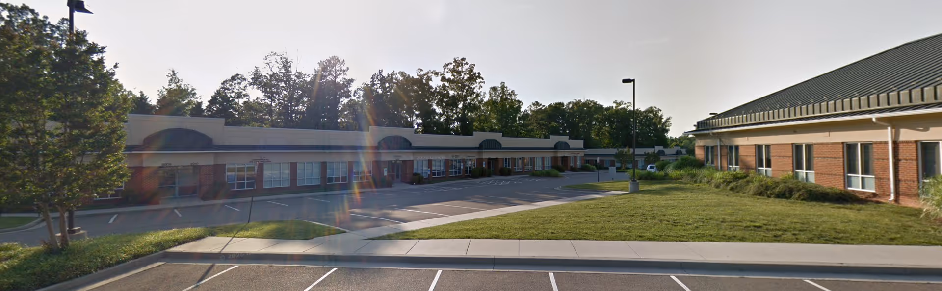 Exterior view of a single-story senior care facility with parking lot.