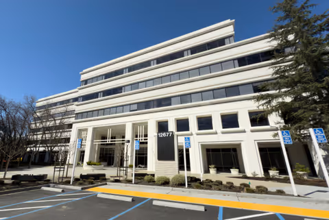 Exterior view of John Muir Health Outpatient Center building with a parking lot in front.